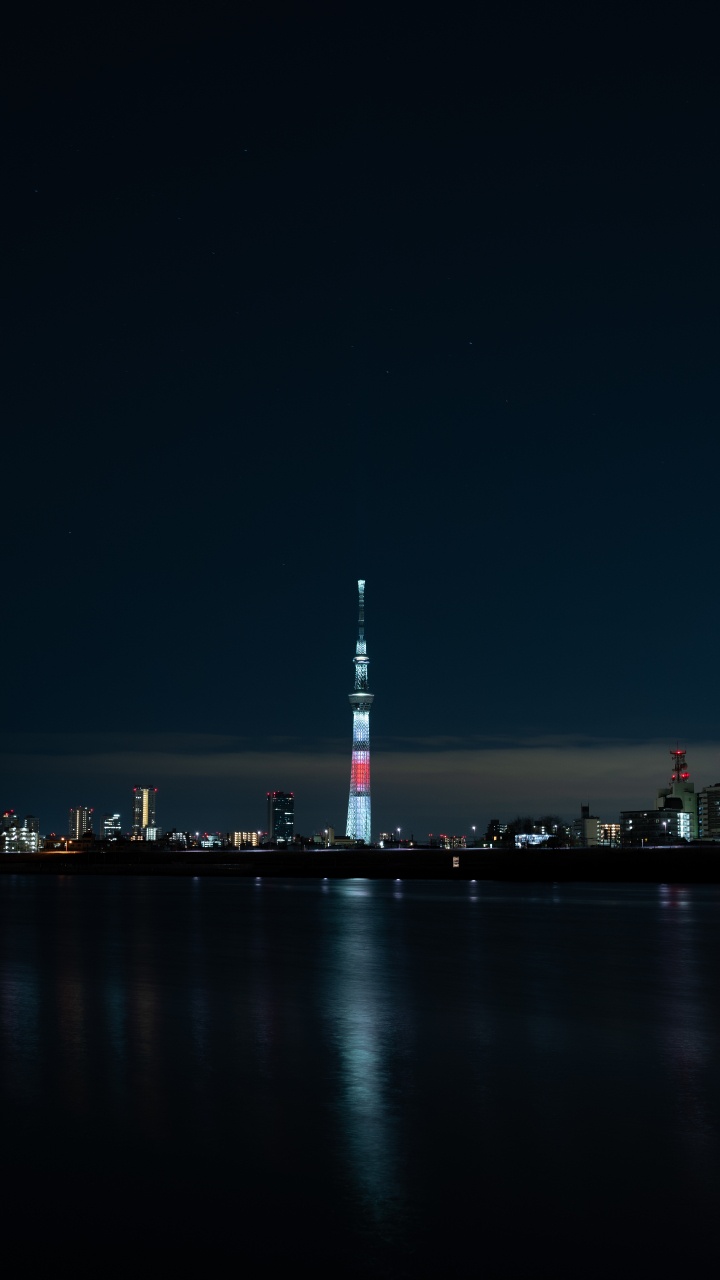 White and Red Tower Near Body of Water During Night Time. Wallpaper in 720x1280 Resolution