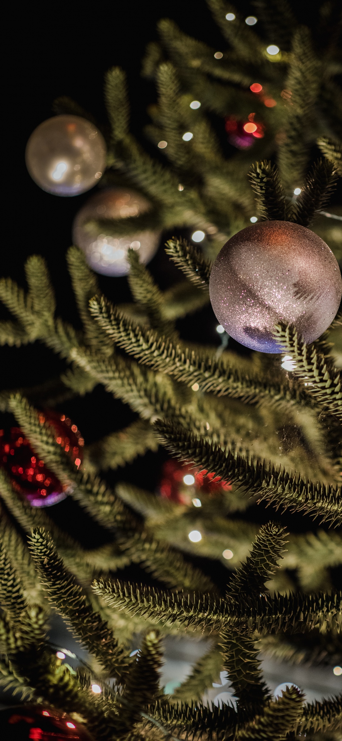 Adornos Azules en el Árbol de Navidad Verde. Wallpaper in 1125x2436 Resolution