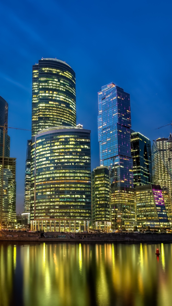 City Skyline Across Body of Water During Night Time. Wallpaper in 720x1280 Resolution