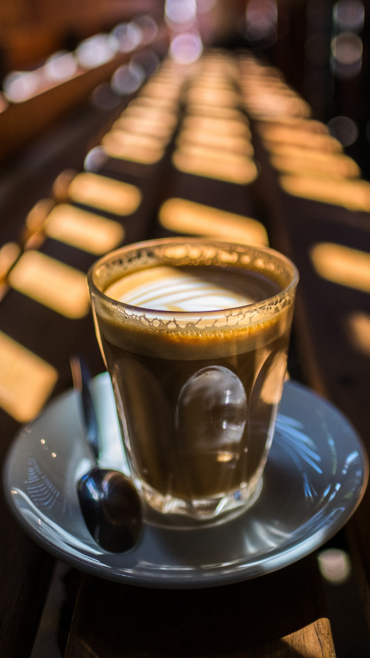Tasse en Verre Clair Sur Une Soucoupe en Céramique Bleue. Wallpaper in 750x1334 Resolution