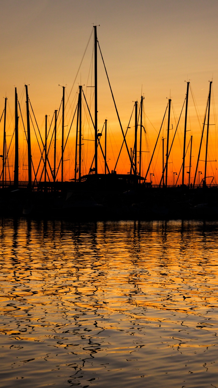Silhouette Des Bootes Auf Dem Wasser Bei Sonnenuntergang. Wallpaper in 720x1280 Resolution