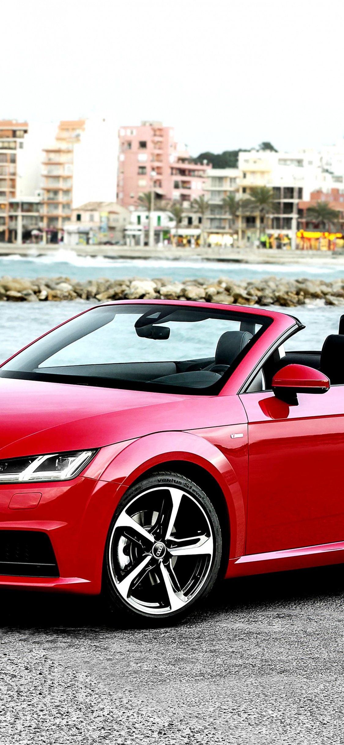 Red Convertible Car Parked Near Body of Water During Daytime. Wallpaper in 1125x2436 Resolution
