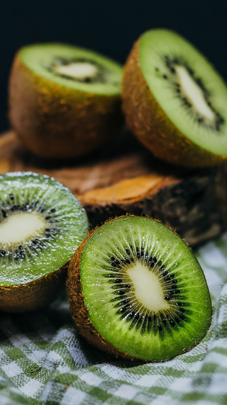 Kiwi Tranché Sur Une Planche à Découper en Bois Marron. Wallpaper in 750x1334 Resolution