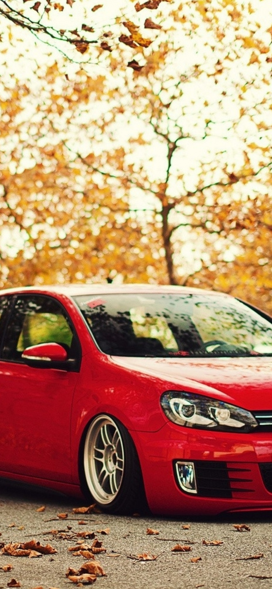 Volkswagen Rojo Hatchback de 5 Puertas en la Carretera Durante el Día. Wallpaper in 1125x2436 Resolution