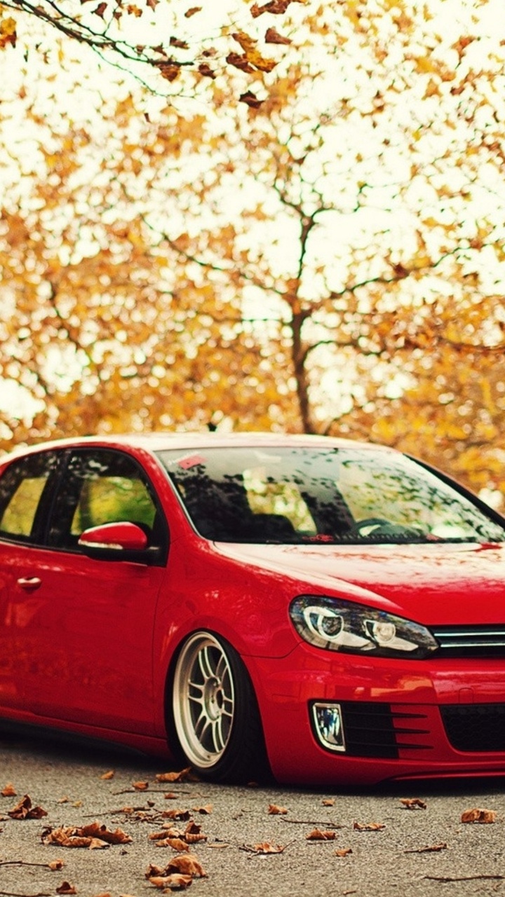 Volkswagen Rojo Hatchback de 5 Puertas en la Carretera Durante el Día. Wallpaper in 720x1280 Resolution