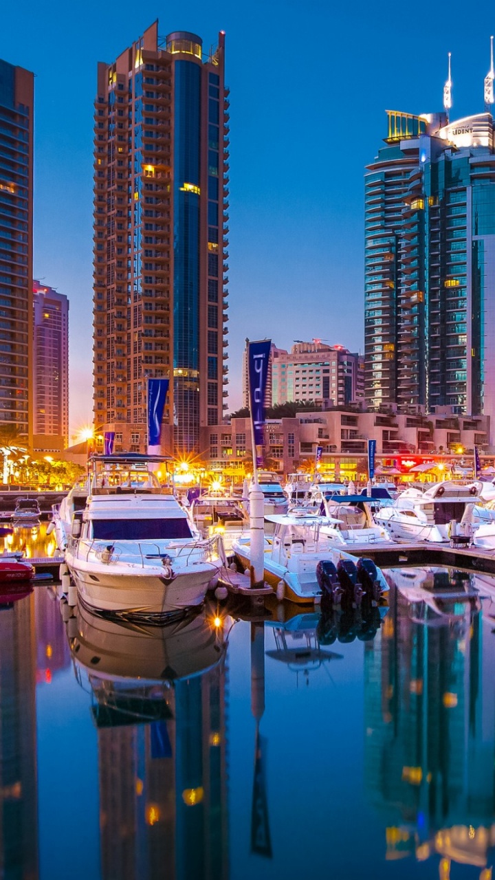 Weißes Und Blaues Boot Auf Dem Wasser in Der Nähe Von Stadtgebäuden Während Der Nacht. Wallpaper in 720x1280 Resolution