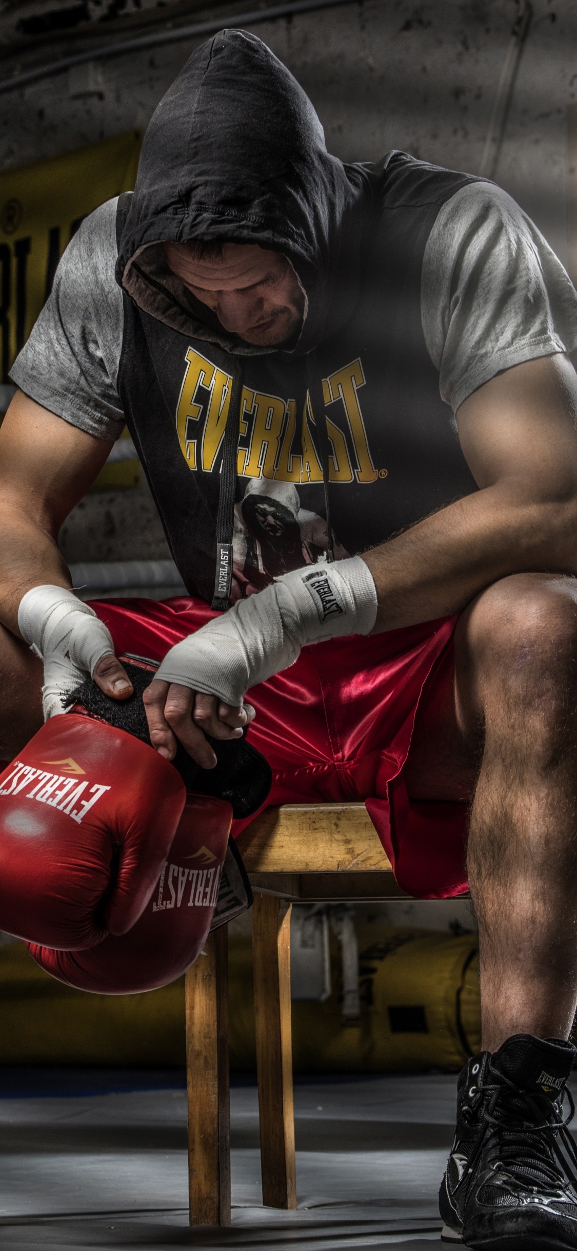 Man in Gray T-shirt and Red Boxing Gloves Doing Push Up. Wallpaper in 1125x2436 Resolution