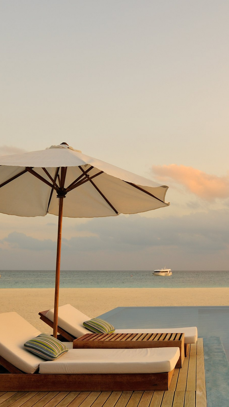White and Brown Wooden Lounge Chairs on Beach During Daytime. Wallpaper in 750x1334 Resolution