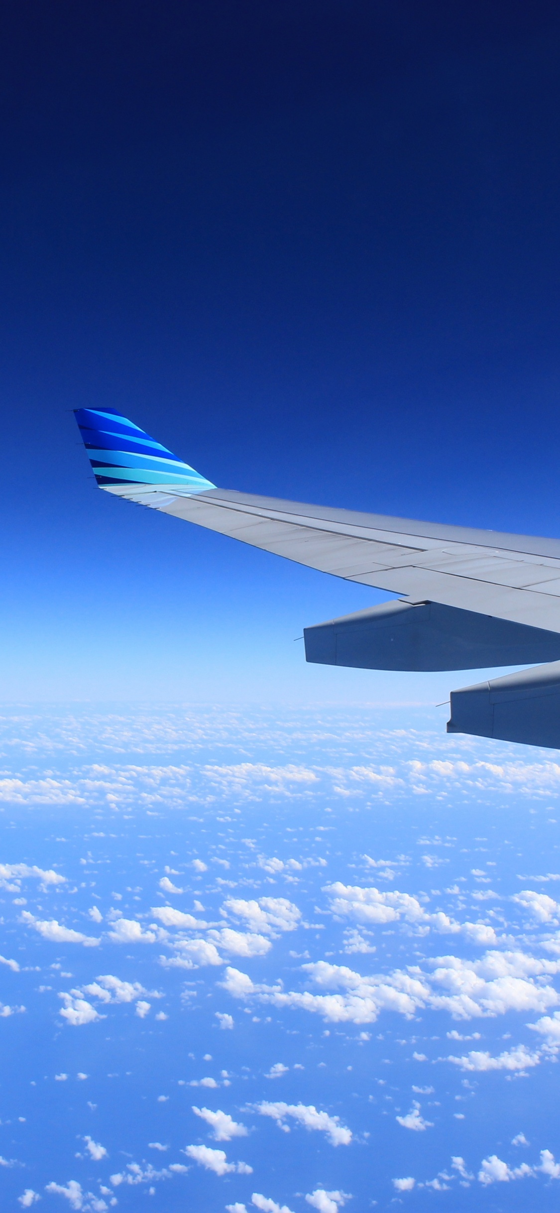 White and Blue Airplane Wing Under Blue Sky During Daytime. Wallpaper in 1125x2436 Resolution