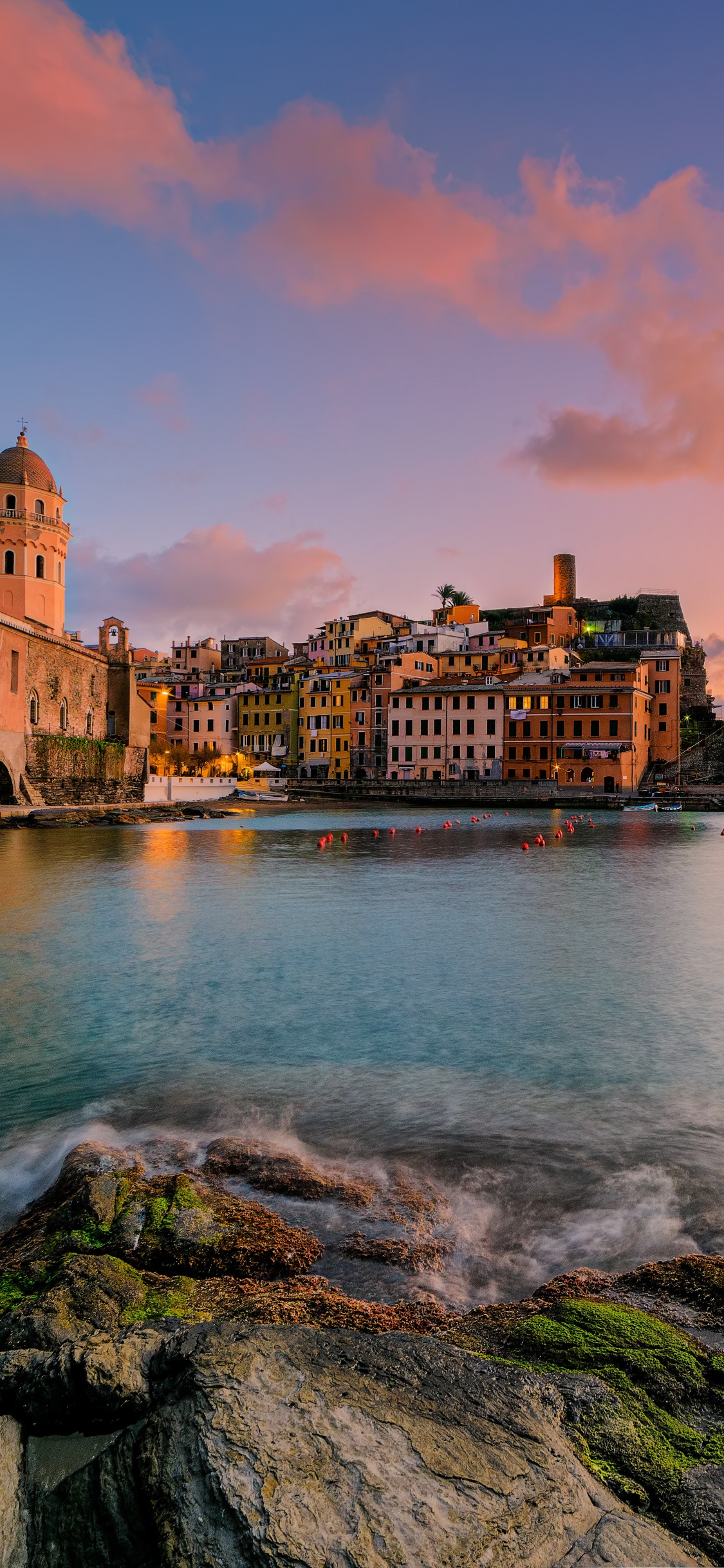 Brown Concrete Building Near Body of Water During Sunset. Wallpaper in 1125x2436 Resolution
