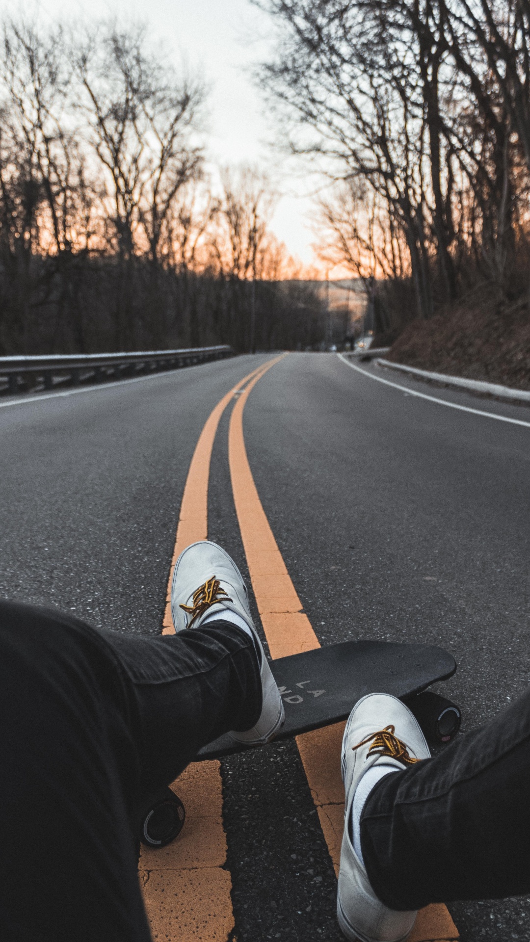 Personne en Pantalon Noir et Baskets Blanches Assise Sur Une Route en Béton Gris Pendant la Journée. Wallpaper in 1080x1920 Resolution