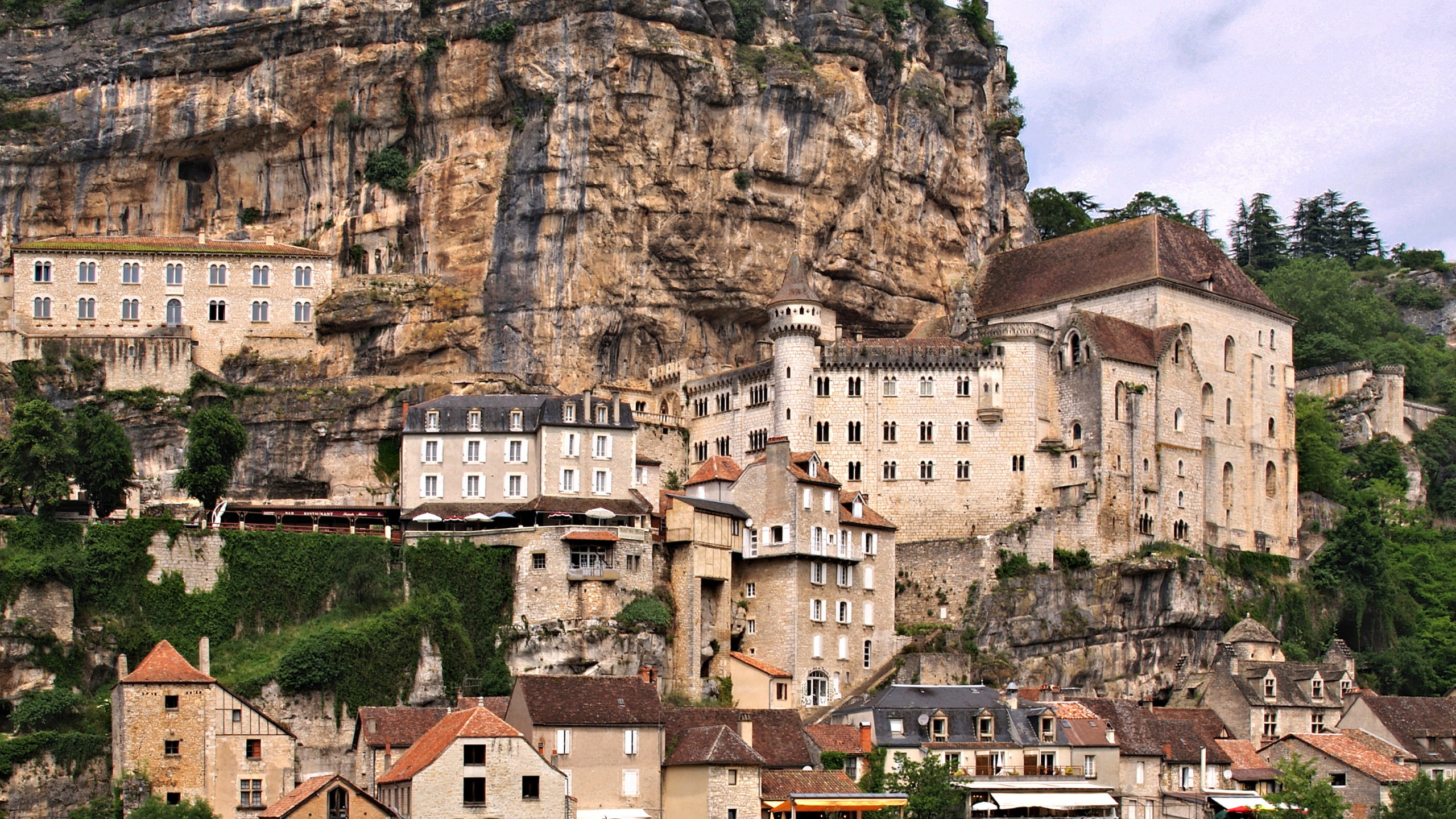 Bâtiment en Béton Brun au Sommet de la Montagne Pendant la Journée. Wallpaper in 2560x1440 Resolution