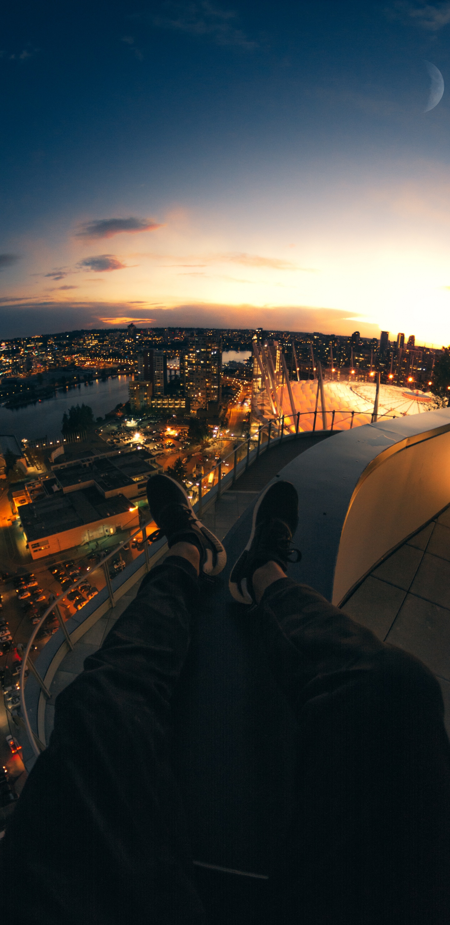 Person in Black Pants Sitting on Roof Top During Night Time. Wallpaper in 1440x2960 Resolution