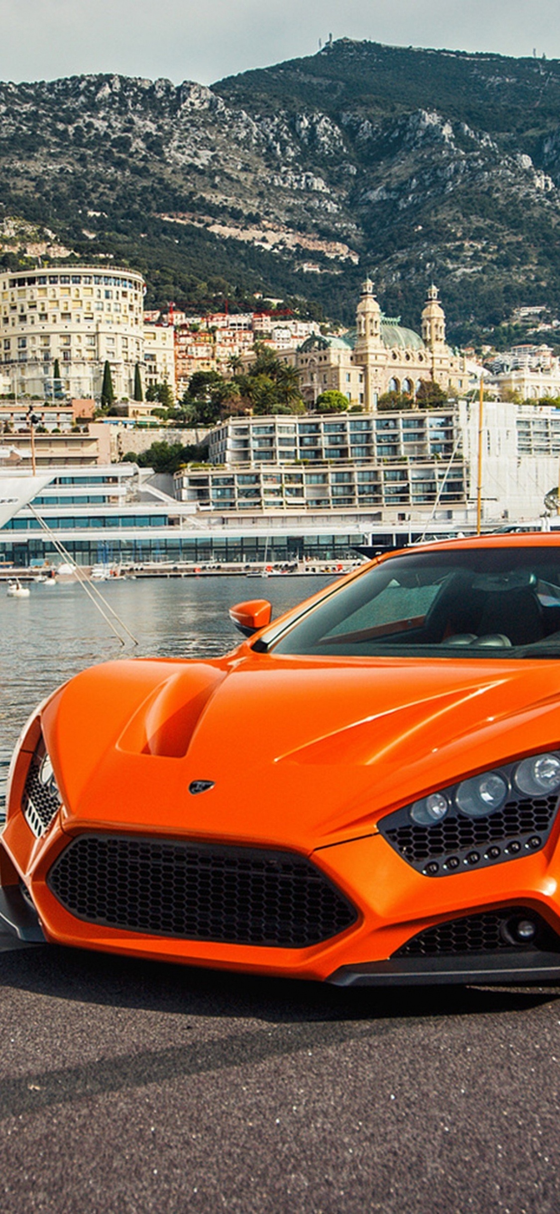 Orange Porsche 911 Parked on Beach Shore During Daytime. Wallpaper in 1125x2436 Resolution