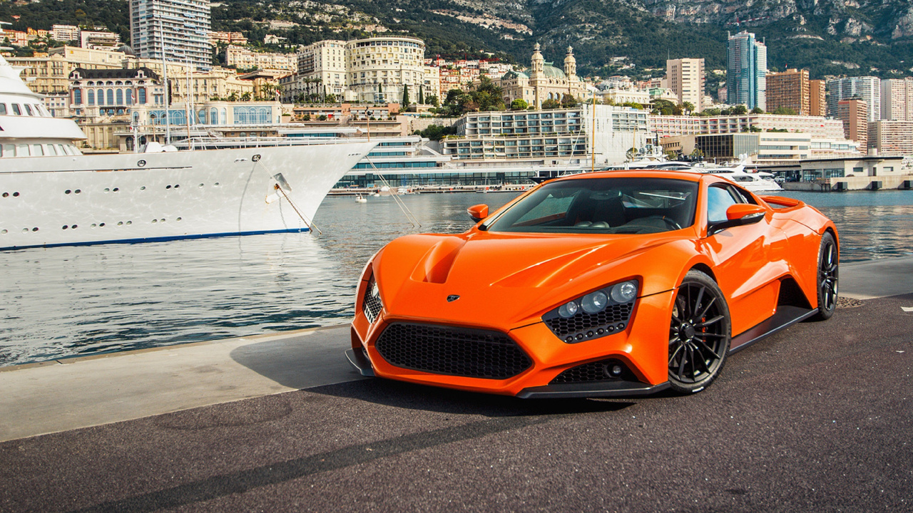 Orange Porsche 911 Parked on Beach Shore During Daytime. Wallpaper in 1280x720 Resolution