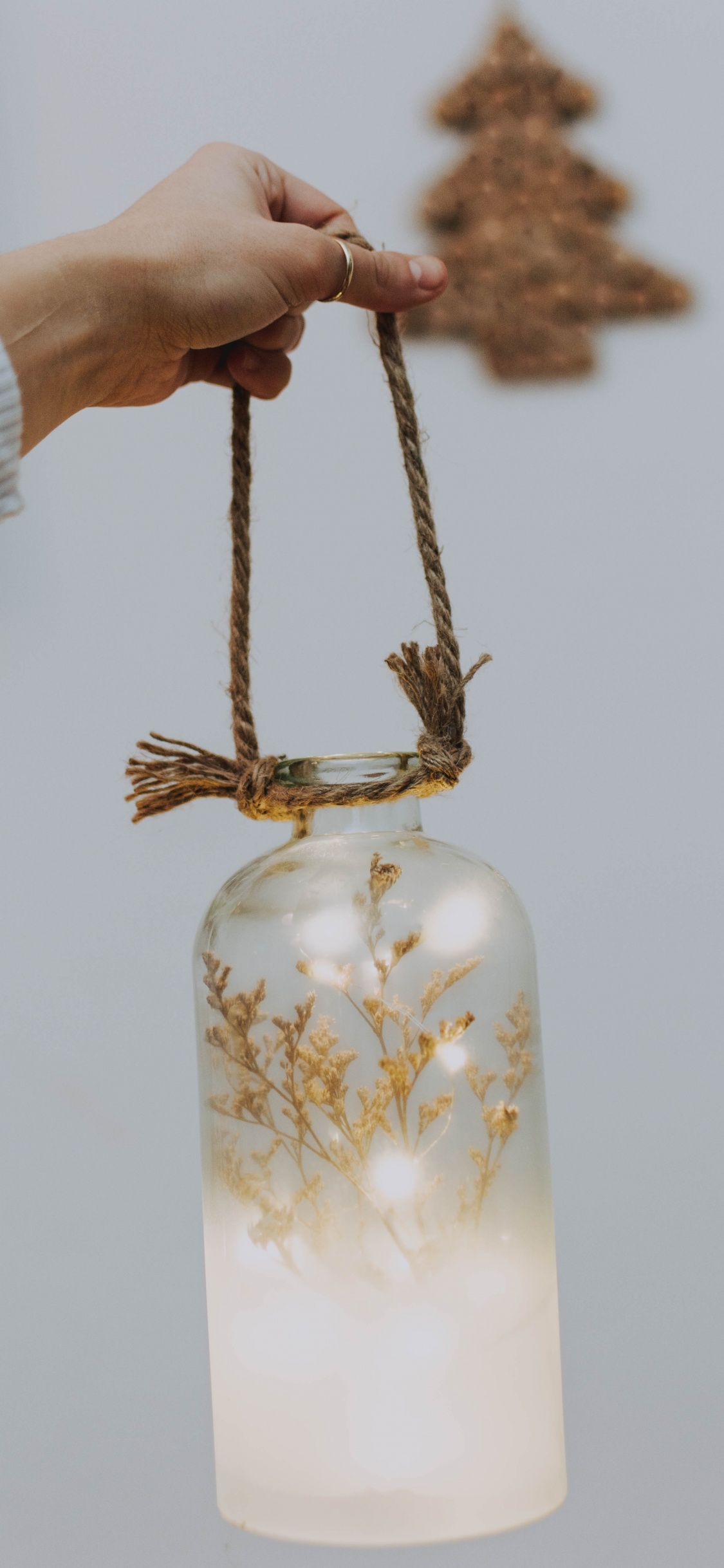 Person Holding Gold Colored Necklace. Wallpaper in 1125x2436 Resolution