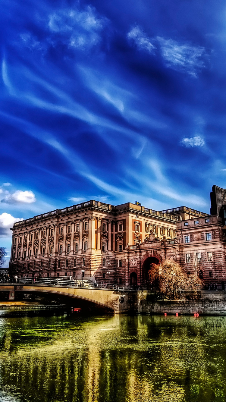 Braunes Betongebäude in Der Nähe Von Gewässern Unter Blauem Himmel Tagsüber. Wallpaper in 750x1334 Resolution