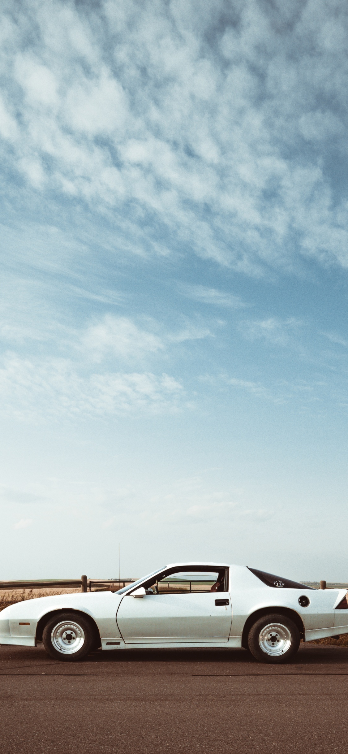 Coupé Blanc Sur Champ Brun Sous Des Nuages Blancs Pendant la Journée. Wallpaper in 1125x2436 Resolution