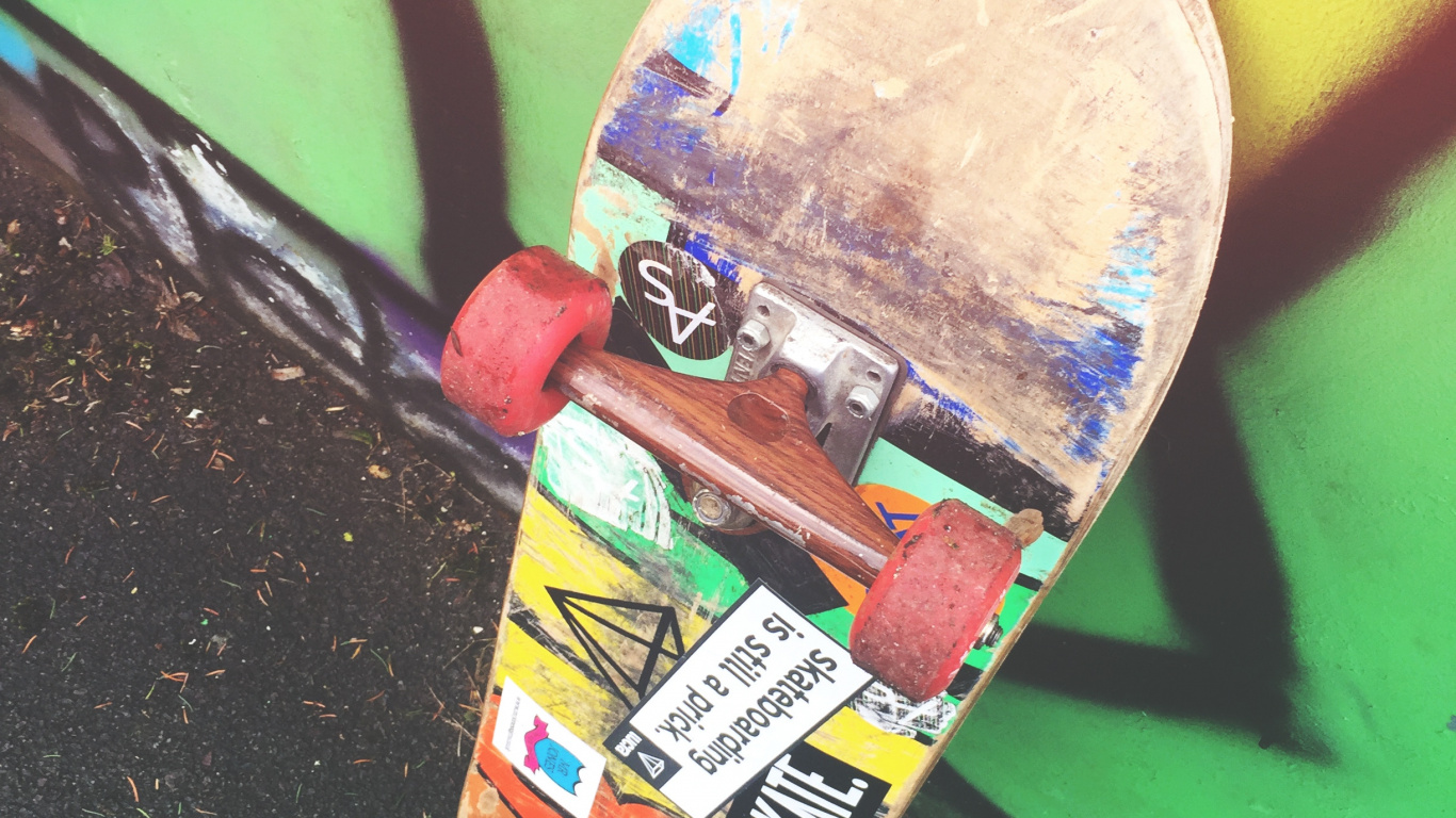Skateboard Rouge et Jaune Sur Mur Vert. Wallpaper in 1366x768 Resolution