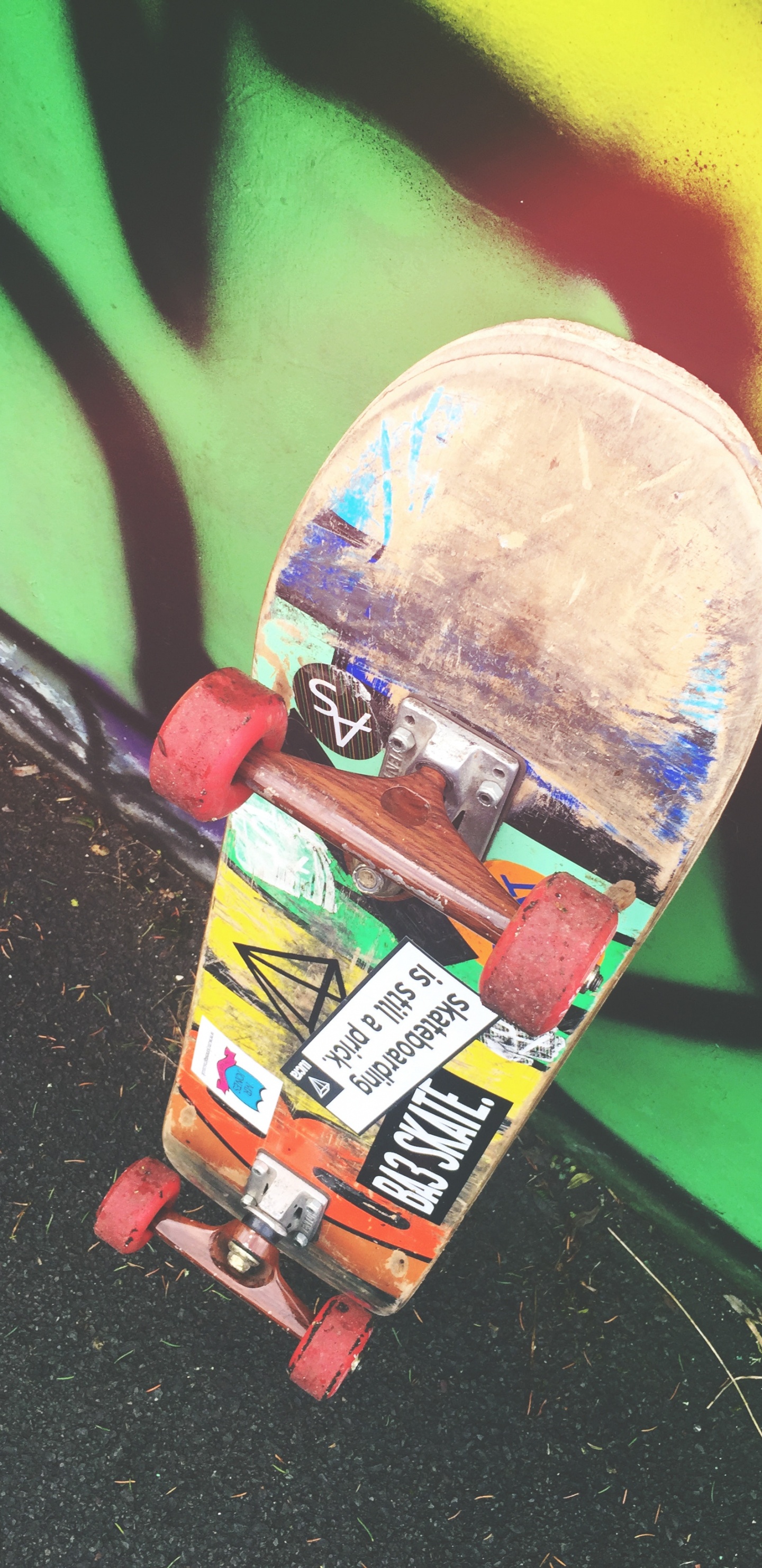 Skateboard Rouge et Jaune Sur Mur Vert. Wallpaper in 1440x2960 Resolution
