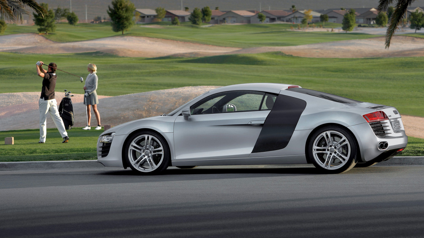 Man in White T-shirt and White Shorts Standing Beside Silver Porsche 911 Coupe During Daytime. Wallpaper in 1366x768 Resolution
