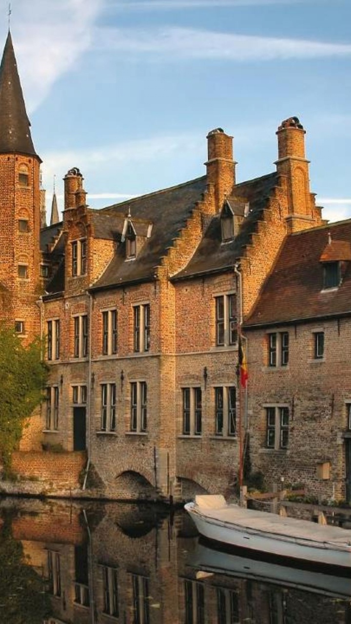 Bâtiment en Béton Brun Près de la Rivière Pendant la Journée. Wallpaper in 720x1280 Resolution