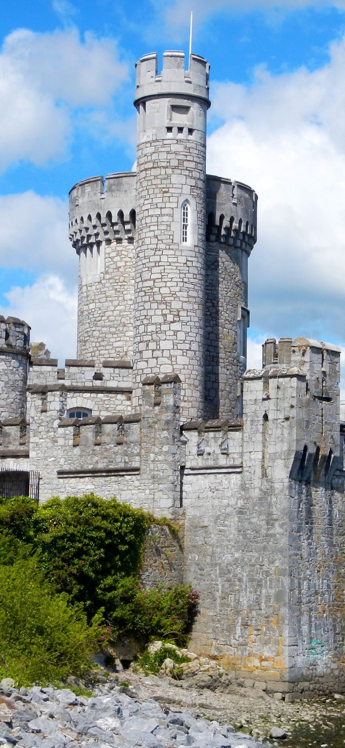 Gray Concrete Castle Near Body of Water During Daytime. Wallpaper in 1125x2436 Resolution