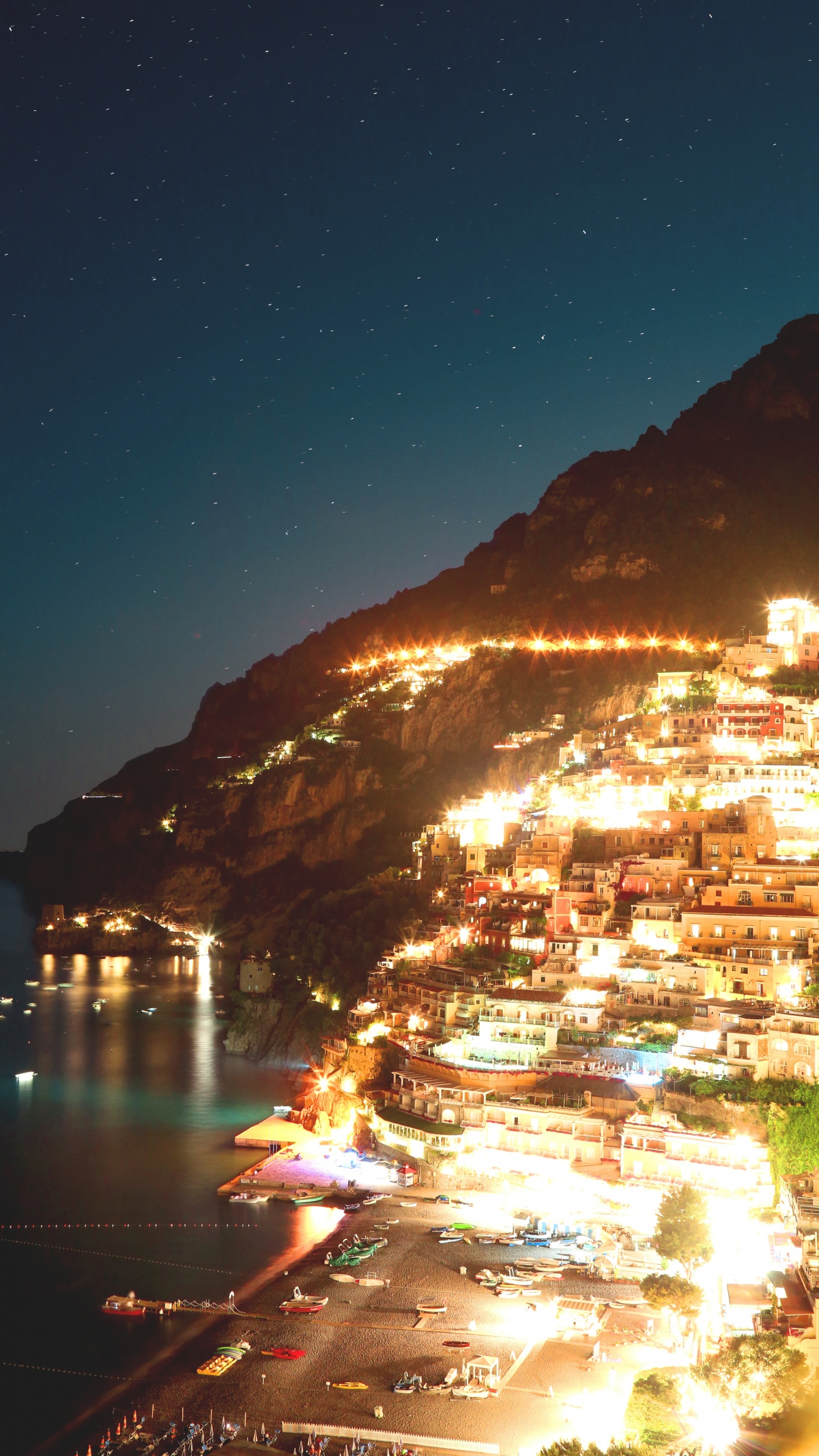 Edificio de Hormigón Blanco y Marrón Cerca Del Cuerpo de Agua Durante la Noche. Wallpaper in 1440x2560 Resolution