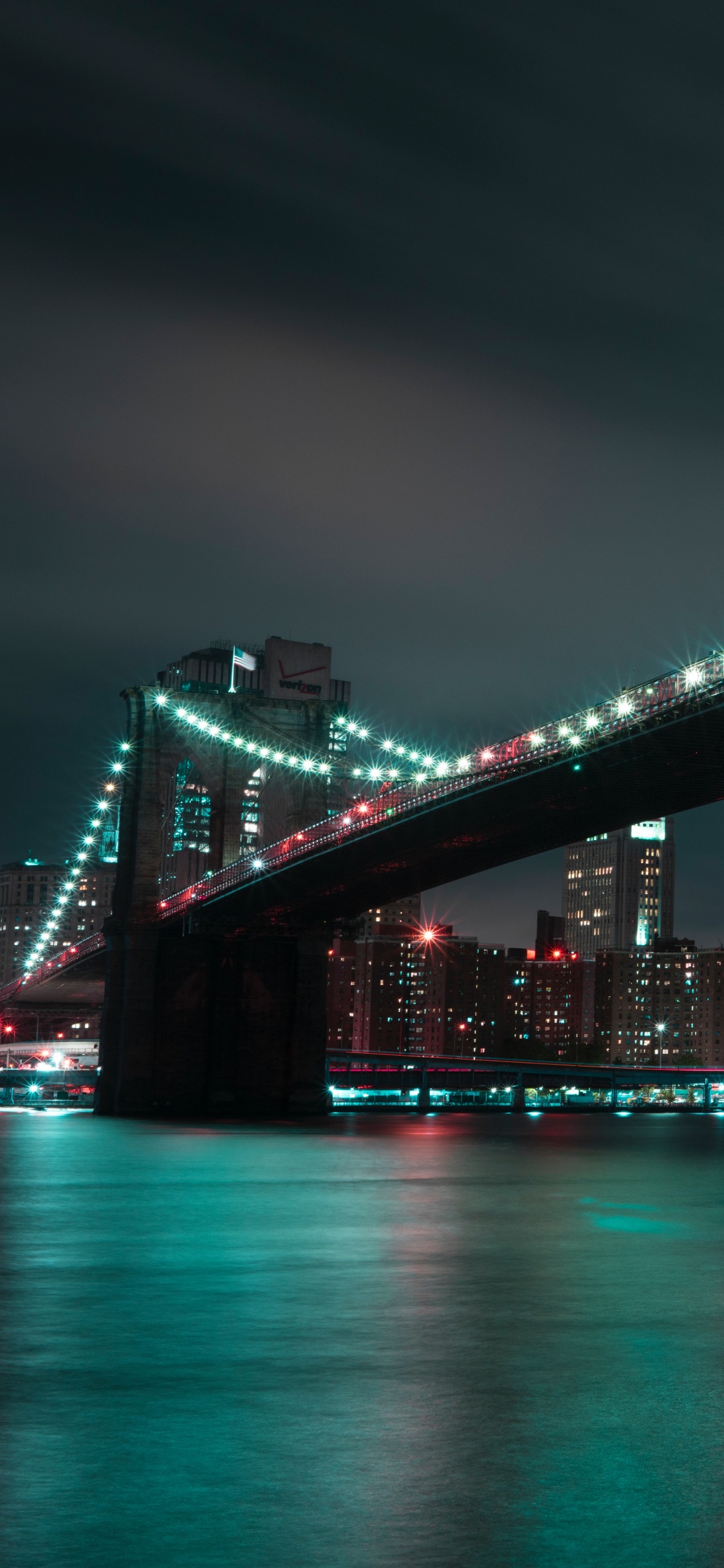 Bridge Over Water During Night Time. Wallpaper in 1125x2436 Resolution