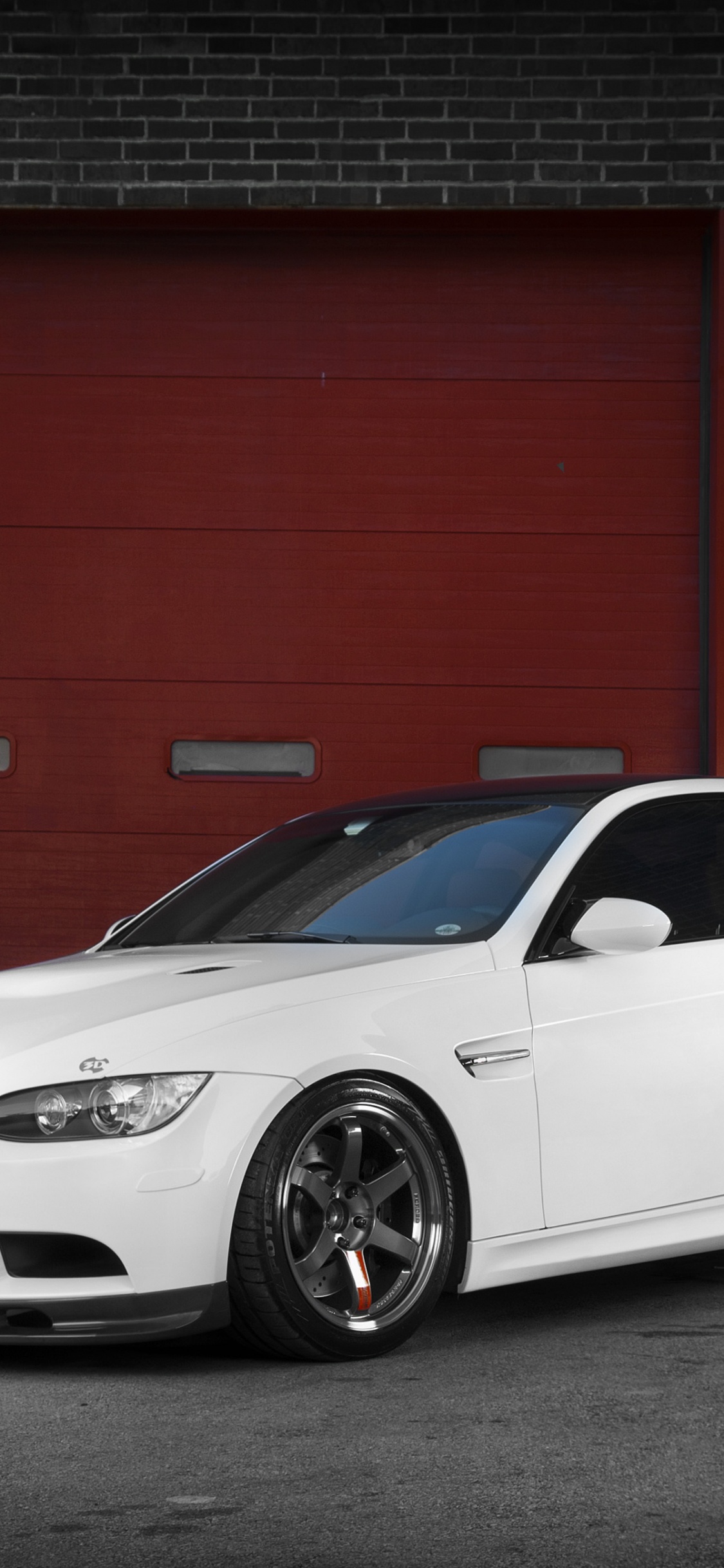 Bmw m 3 Coupe Blanco Estacionado Junto a la Pared Roja. Wallpaper in 1125x2436 Resolution