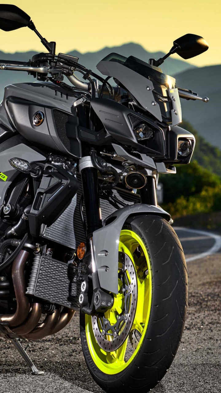 Schwarzes Und Gelbes Motorrad Auf Grauem Sand Tagsüber. Wallpaper in 720x1280 Resolution