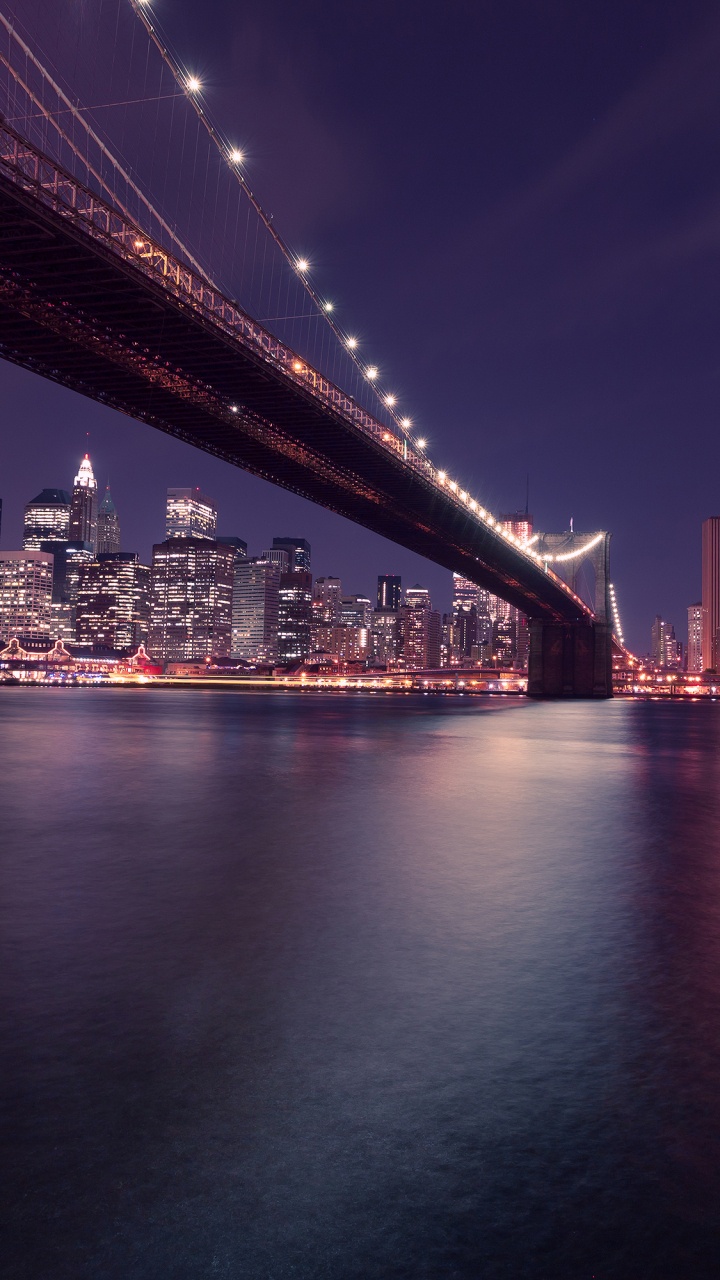 Pont Éclairé Au-dessus D'un Plan D'eau Pendant la Nuit. Wallpaper in 720x1280 Resolution