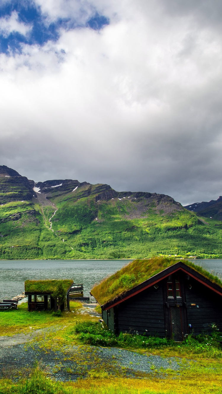 Casa de Madera Marrón en el Campo de Hierba Verde Cerca Del Lago Bajo Las Nubes Blancas y el Cielo Azul Durante. Wallpaper in 750x1334 Resolution