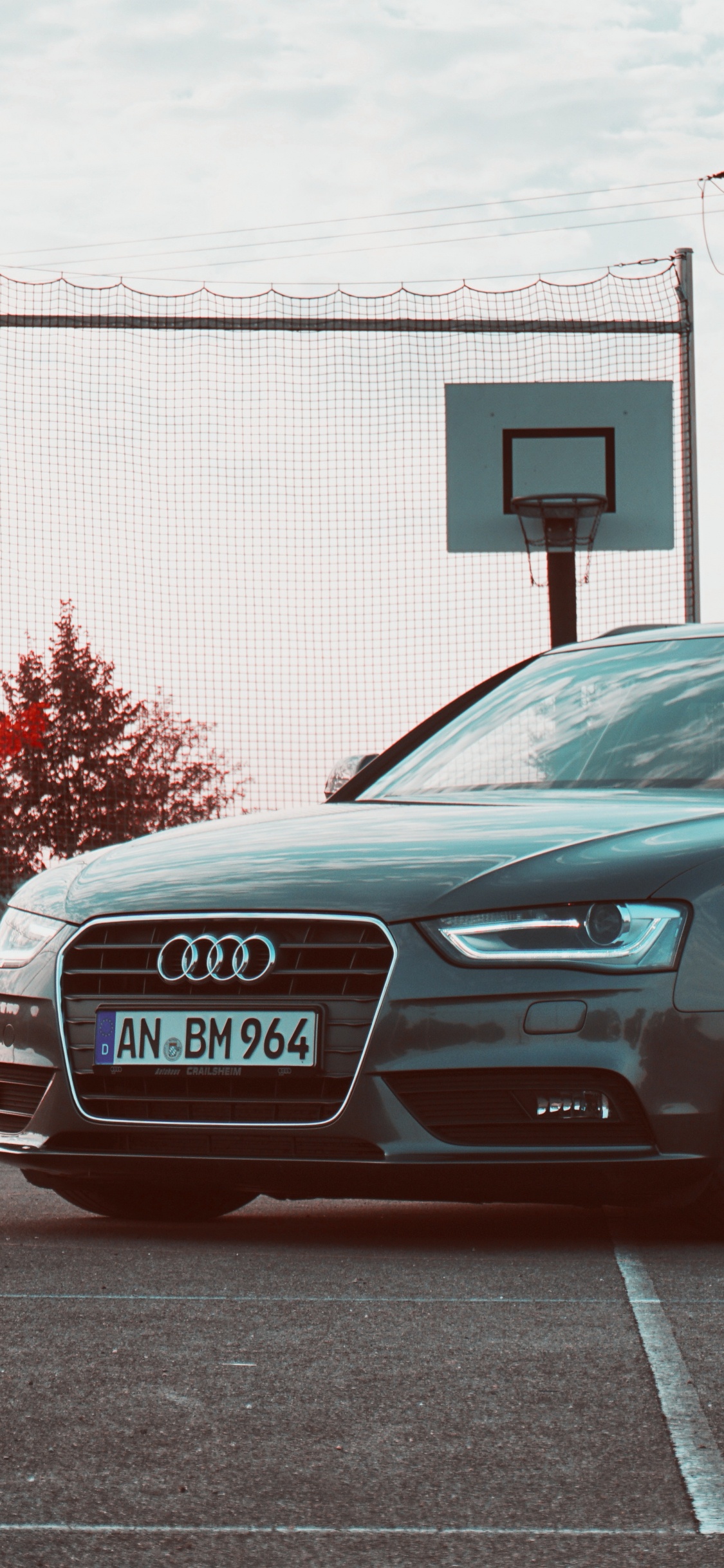 Black Audi Sedan Parked on Gray Concrete Road During Daytime. Wallpaper in 1125x2436 Resolution