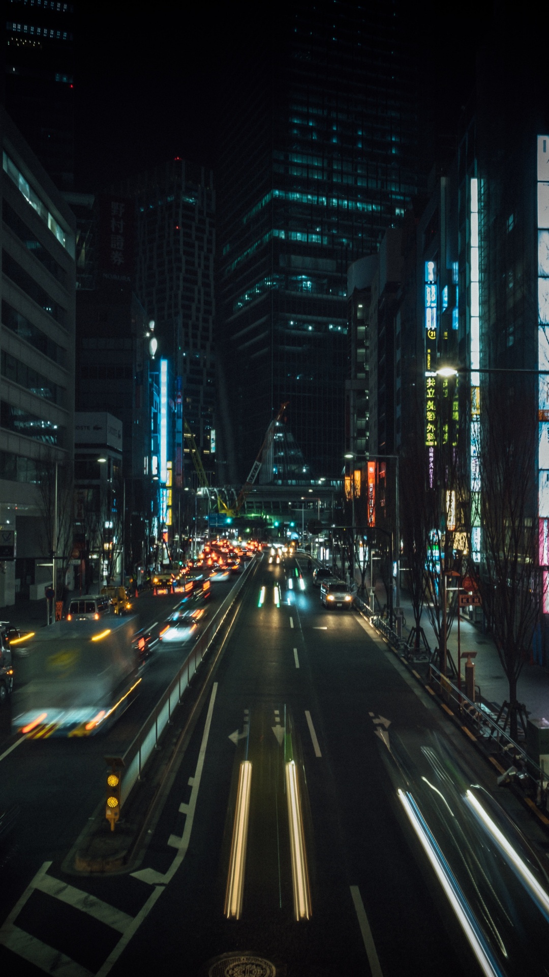 Autos Auf Der Straße Zwischen Hochhäusern Während Der Nacht. Wallpaper in 1080x1920 Resolution