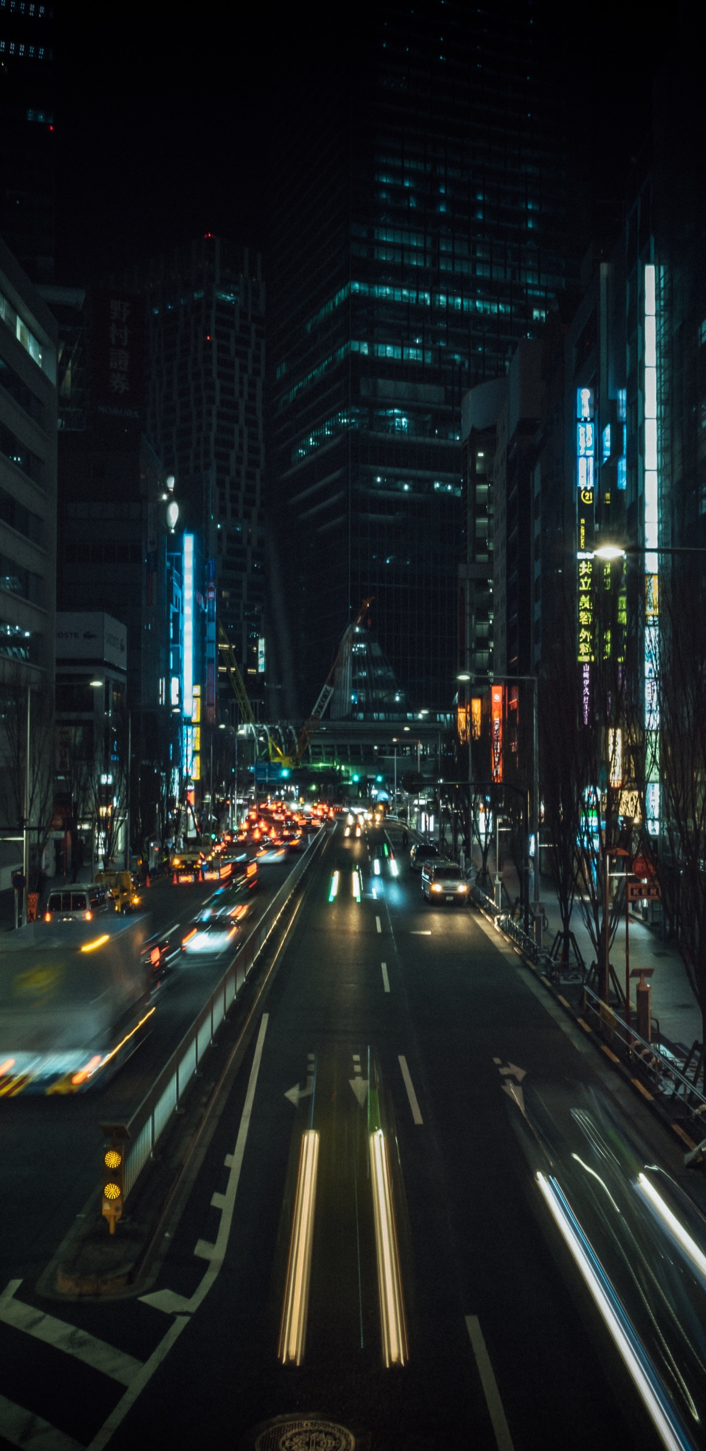 Autos Auf Der Straße Zwischen Hochhäusern Während Der Nacht. Wallpaper in 1440x2960 Resolution