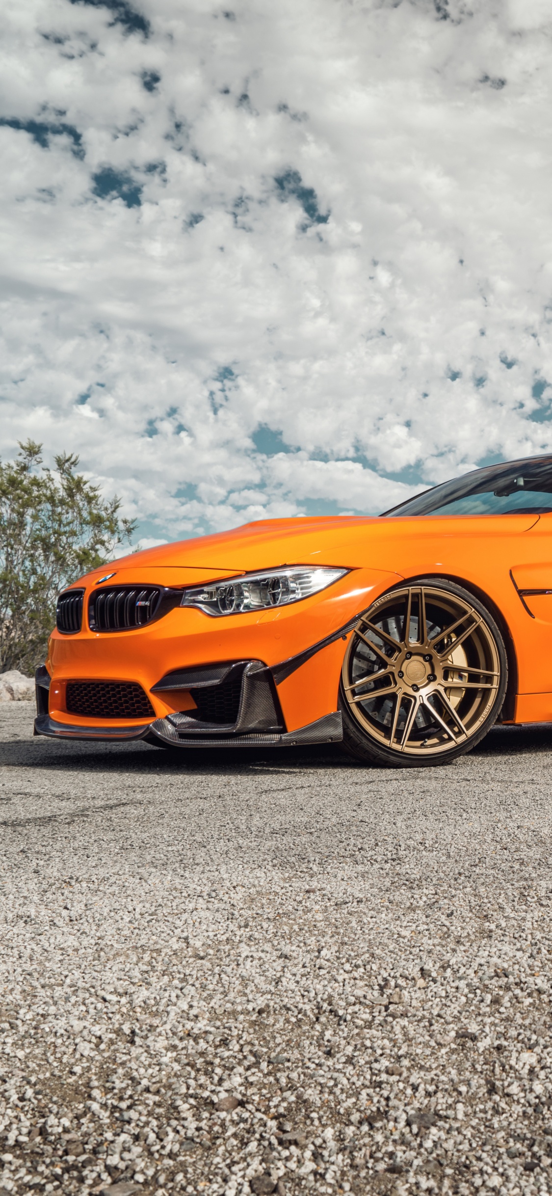 Porsche 911 Naranja Sobre Roca Gris Bajo Nubes Blancas Durante el Día. Wallpaper in 1125x2436 Resolution