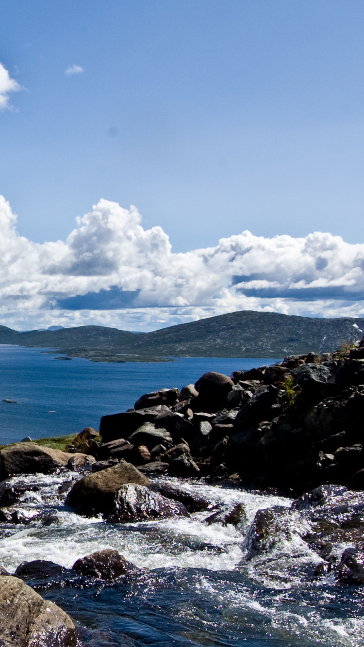 Rocky Shore Under Blue Sky and White Clouds During Daytime. Wallpaper in 750x1334 Resolution