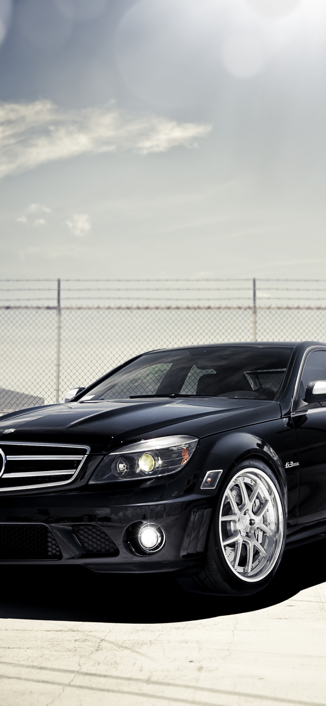 Schwarzes Mercedes-Benz-Coupé, Das Tagsüber in Der Nähe Eines Weißen Metallzauns Geparkt Ist. Wallpaper in 1125x2436 Resolution