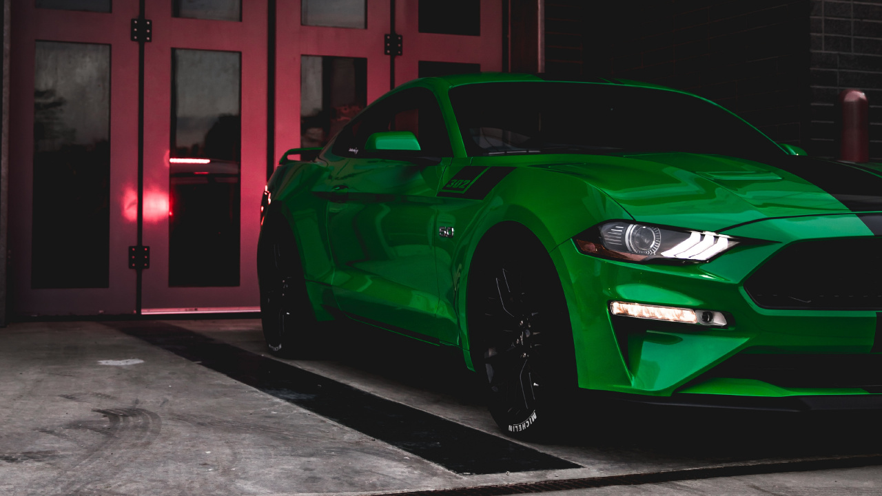 Green Porsche 911 Parked in Front of Brown Wooden Building. Wallpaper in 1280x720 Resolution