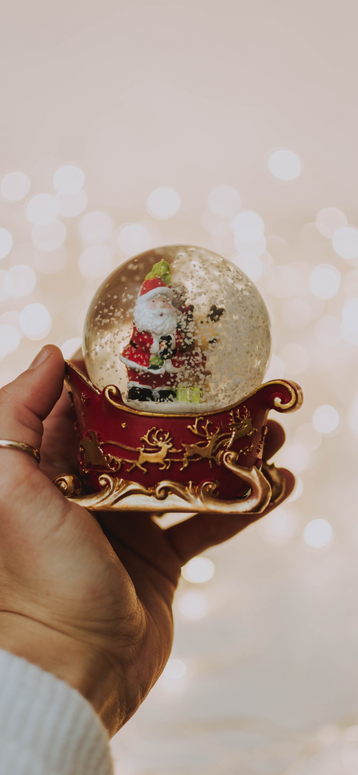 Person Holding White and Red Christmas Bauble. Wallpaper in 1242x2688 Resolution