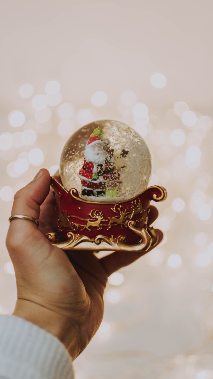 Person Holding White and Red Christmas Bauble. Wallpaper in 720x1280 Resolution