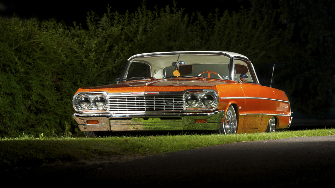 Coche Chevrolet Naranja Estacionado en el Campo de Hierba Verde Durante el Día. Wallpaper in 1366x768 Resolution