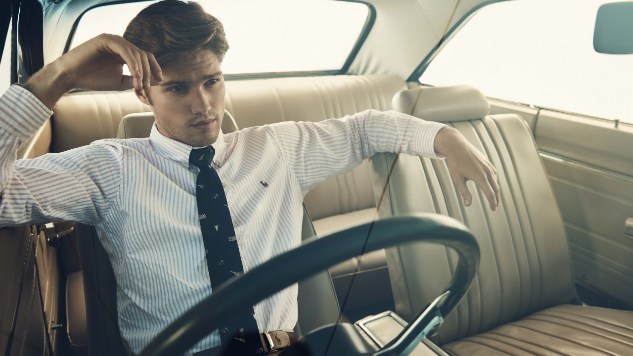 Man in White and Black Striped Long Sleeve Shirt Driving Car. Wallpaper in 1280x720 Resolution