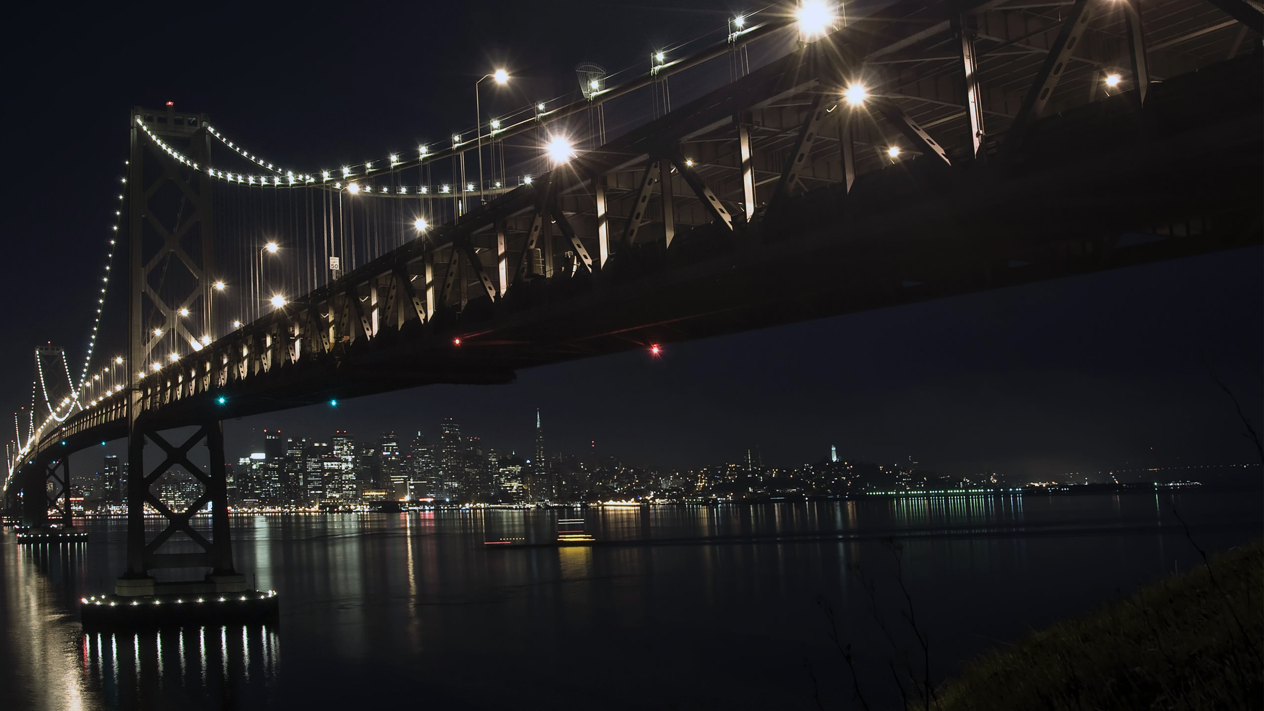 Lighted Bridge Over Body of Water During Night Time. Wallpaper in 2560x1440 Resolution