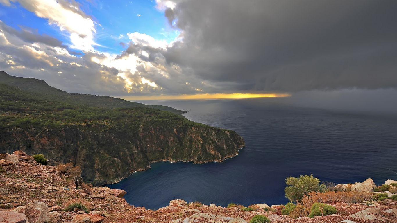 Montaña Verde y Marrón Junto al Mar Azul Bajo un Cielo Azul Durante el Día. Wallpaper in 1366x768 Resolution