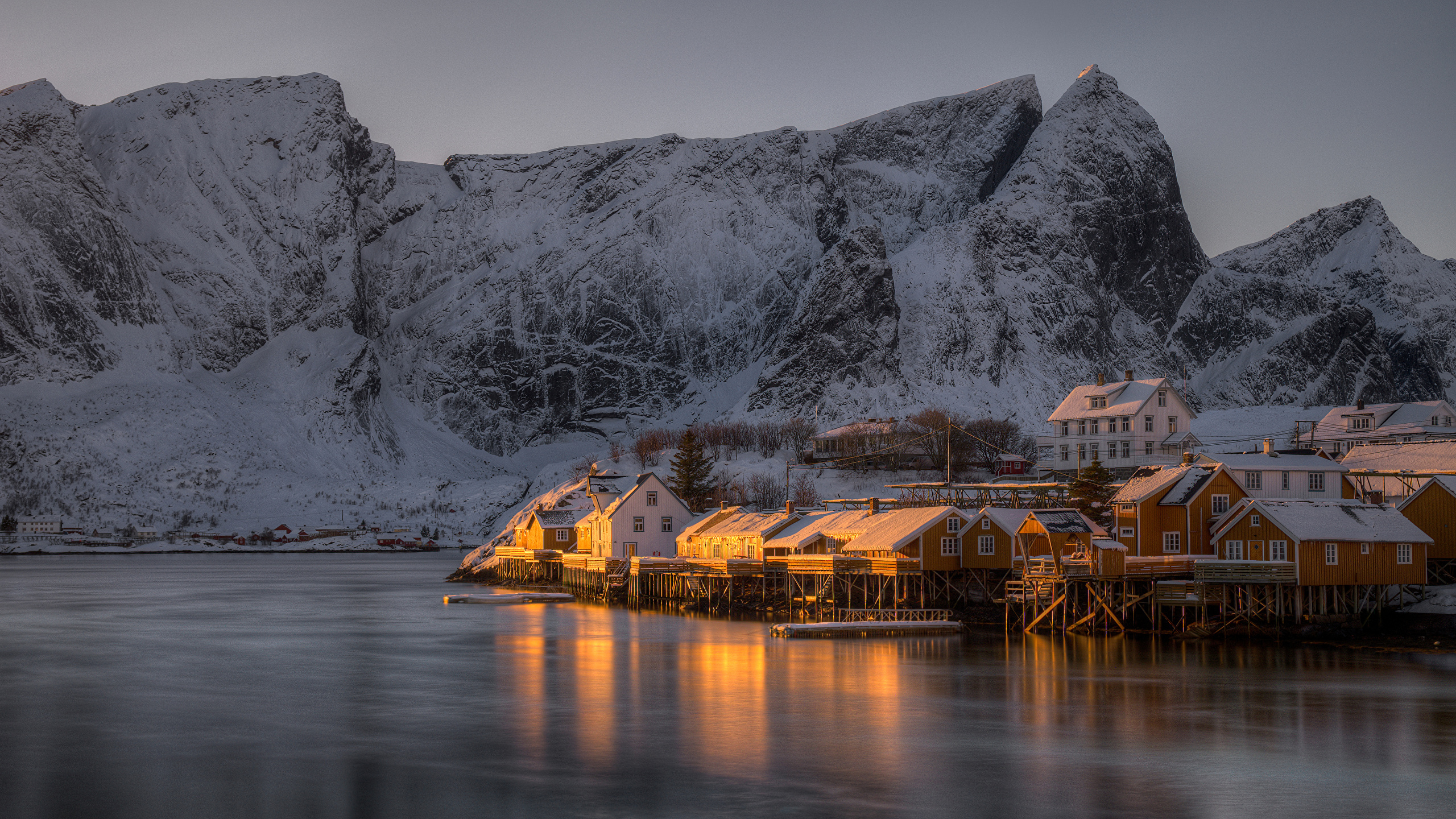 Brown Wooden House on Body of Water Near Gray Mountain During Daytime. Wallpaper in 2560x1440 Resolution