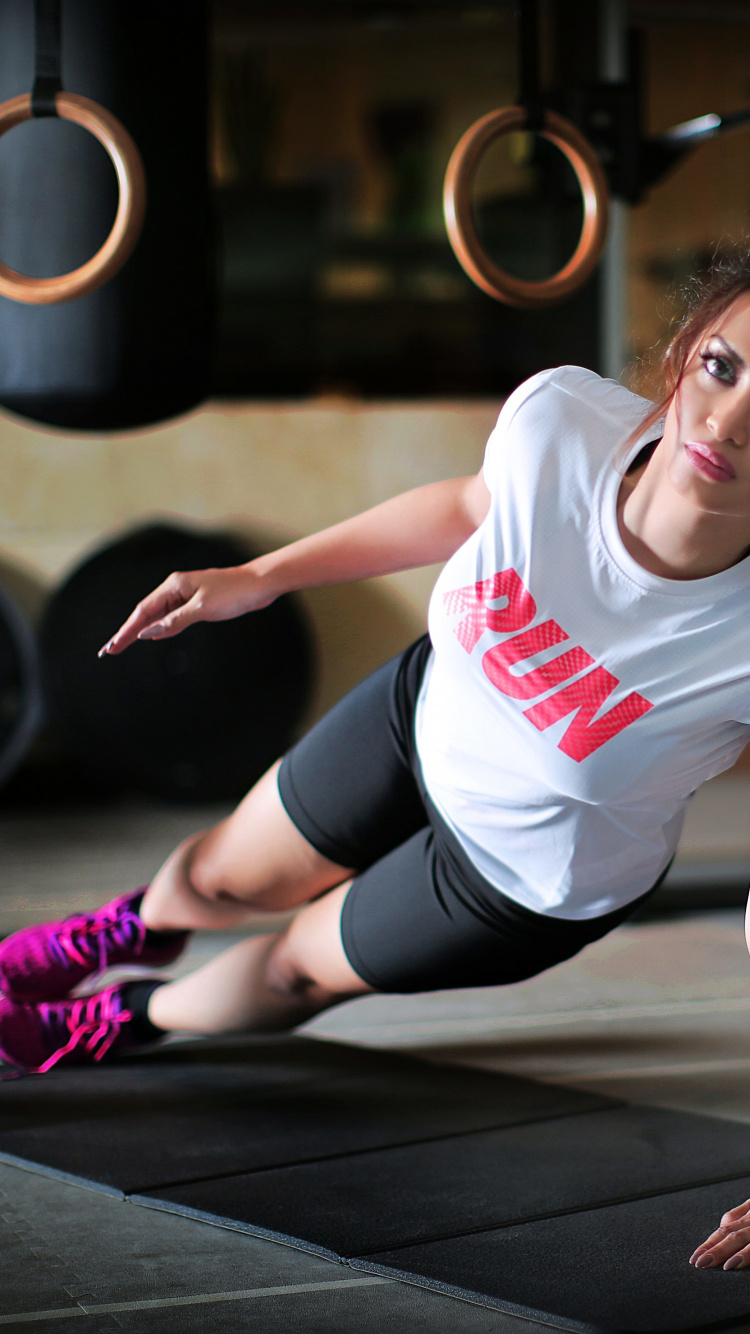 Woman in White Crew Neck T-shirt and Black Shorts Sitting on Black Wooden Floor. Wallpaper in 750x1334 Resolution