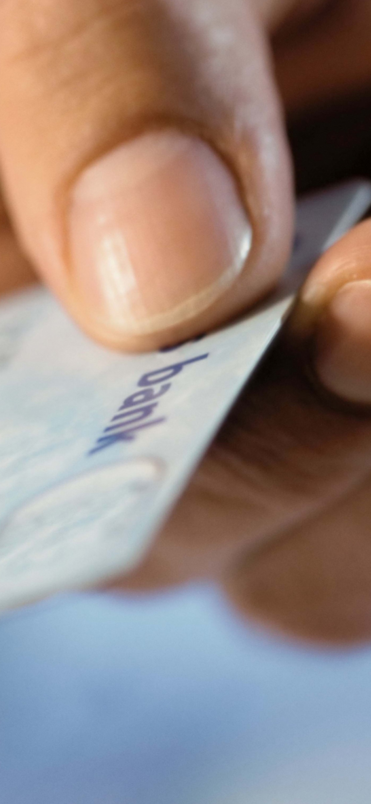 Person Holding White and Blue Card. Wallpaper in 1242x2688 Resolution