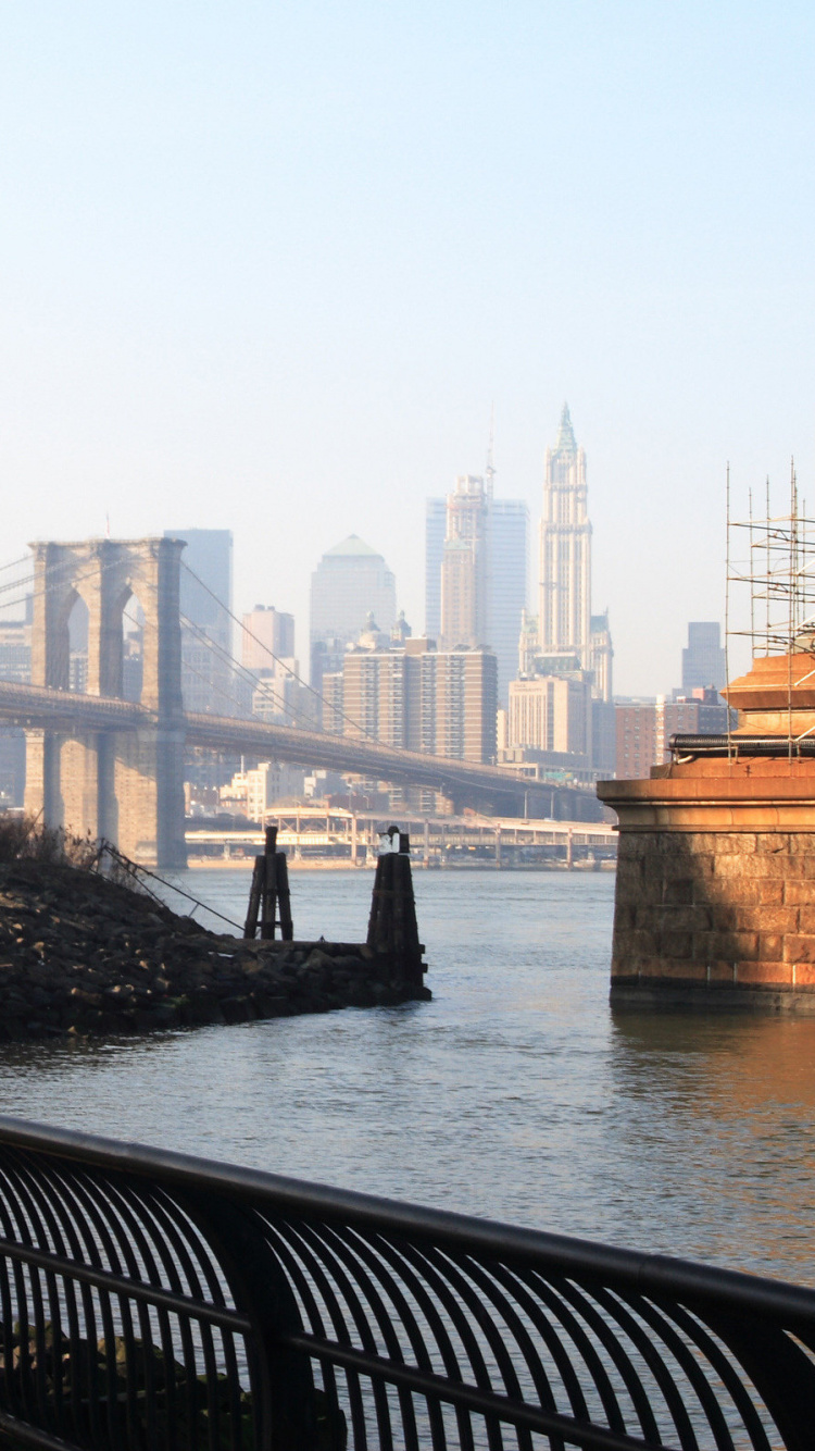 Schwarze Metallbank in Der Nähe Eines Gewässers Tagsüber. Wallpaper in 750x1334 Resolution